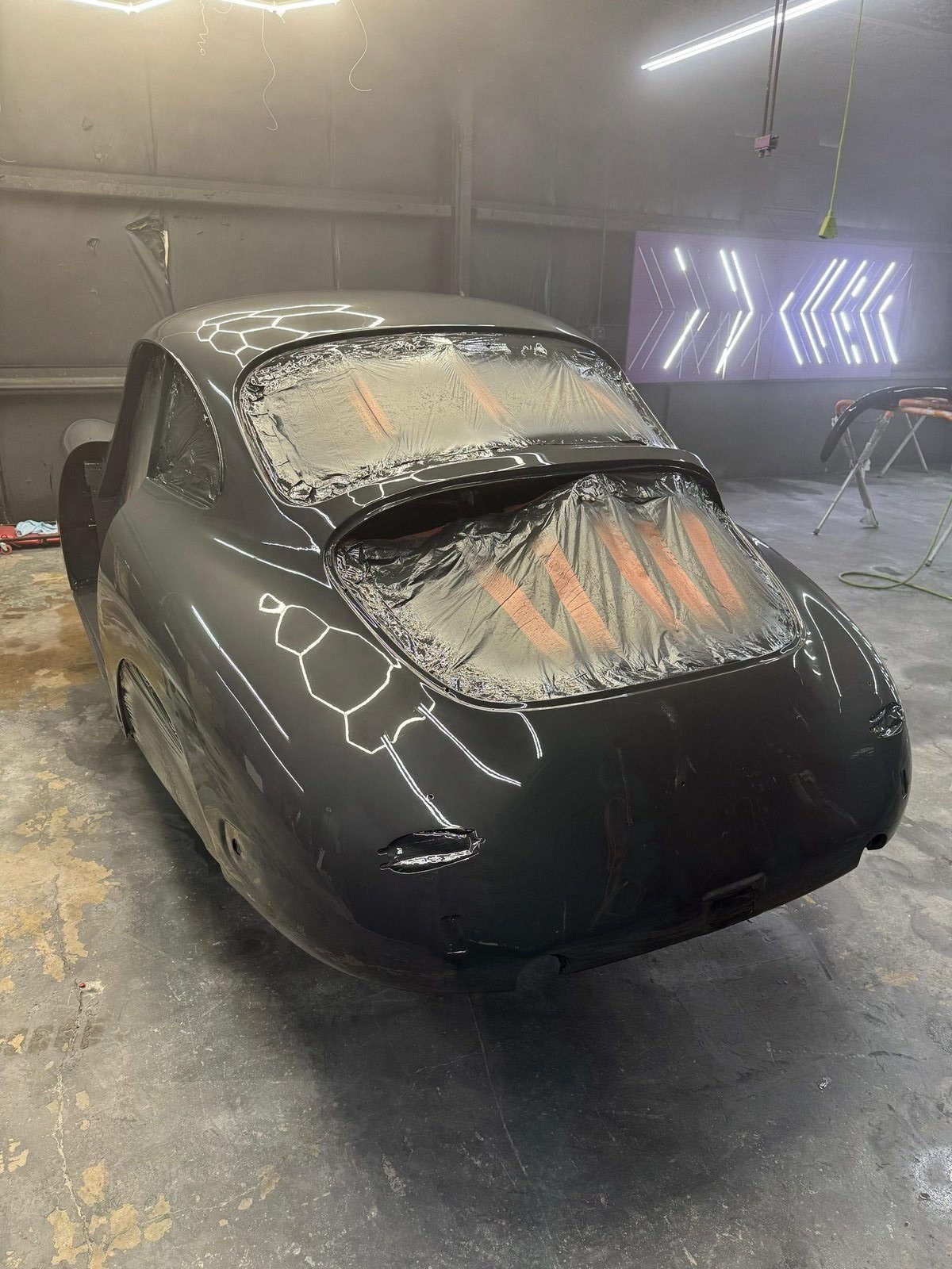 Porsche 356 SC just sprayed with Slate Grey color coat — fresh wet glossy finish on the rear deck